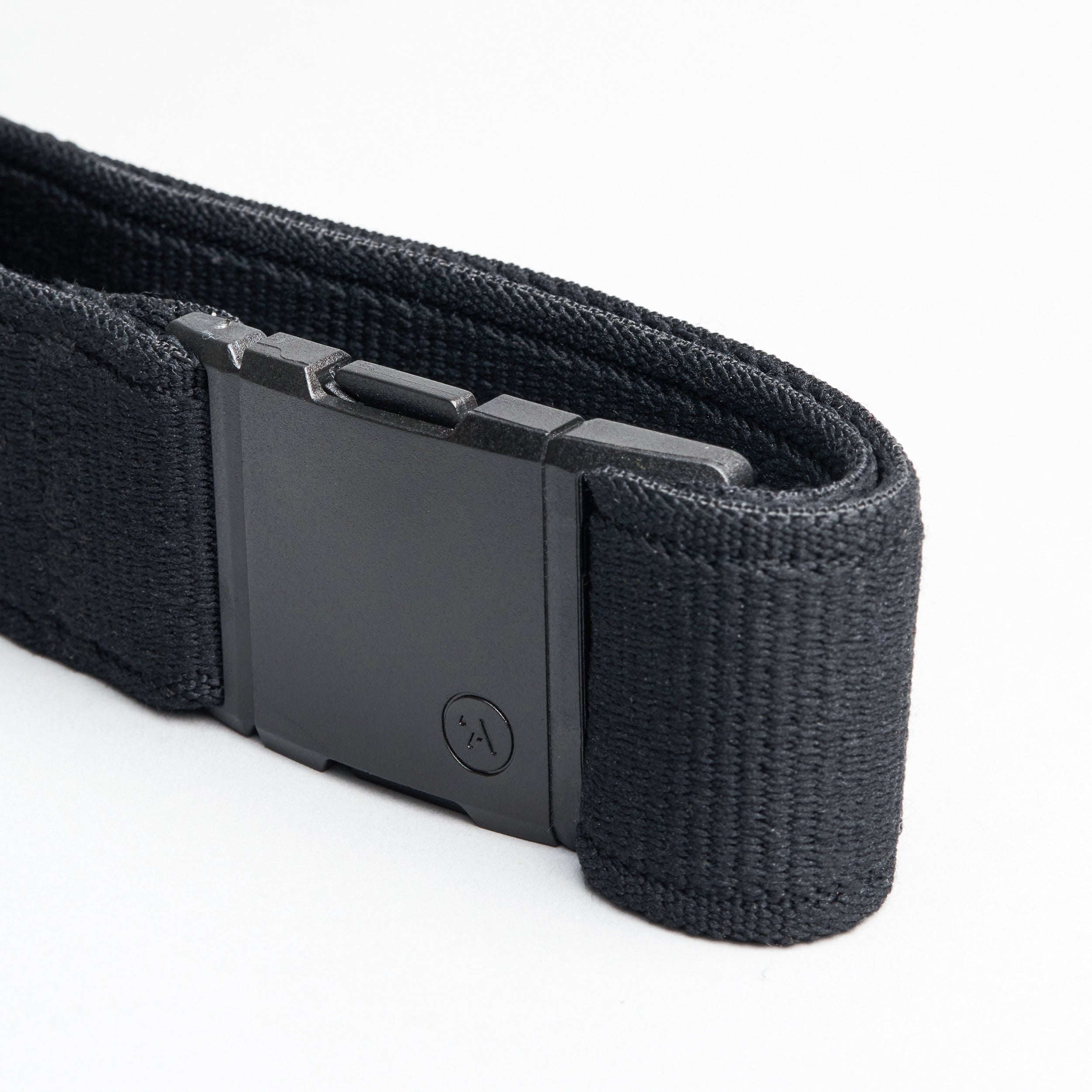 A close-up of the Arcade Belts Atlas, a black elastic stretch belt with a rectangular plastic buckle featuring a subtle logo, displayed on a white background. The webbing texture is clearly visible.