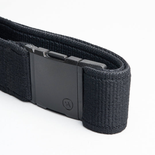 A close-up of the Arcade Belts Atlas, a black elastic stretch belt with a rectangular plastic buckle featuring a subtle logo, displayed on a white background. The webbing texture is clearly visible.