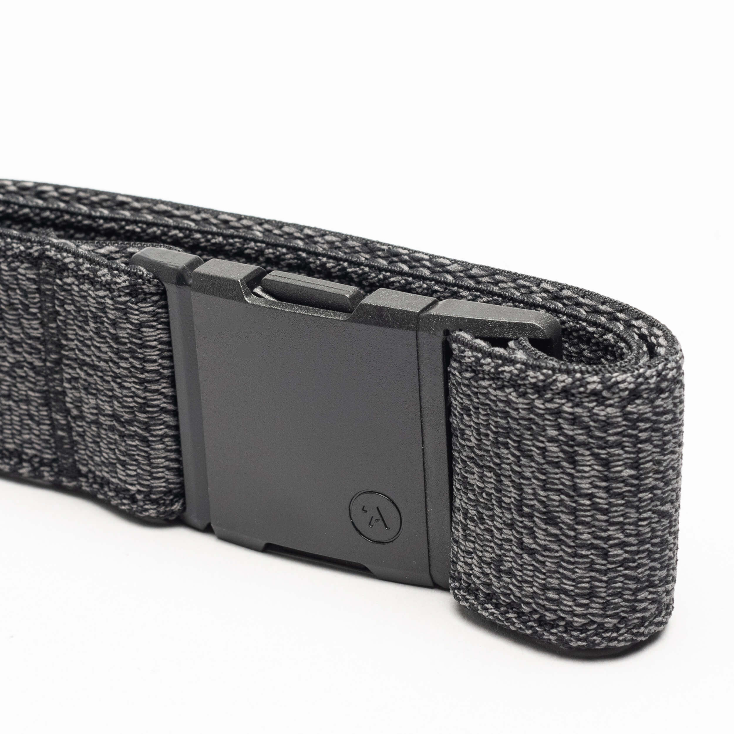 A close-up of the Atlas belt by Arcade Belts, showing its black elastic stretch design with a matte black rectangular buckle and a textured woven pattern with lighter gray threads, neatly folded on a white background.