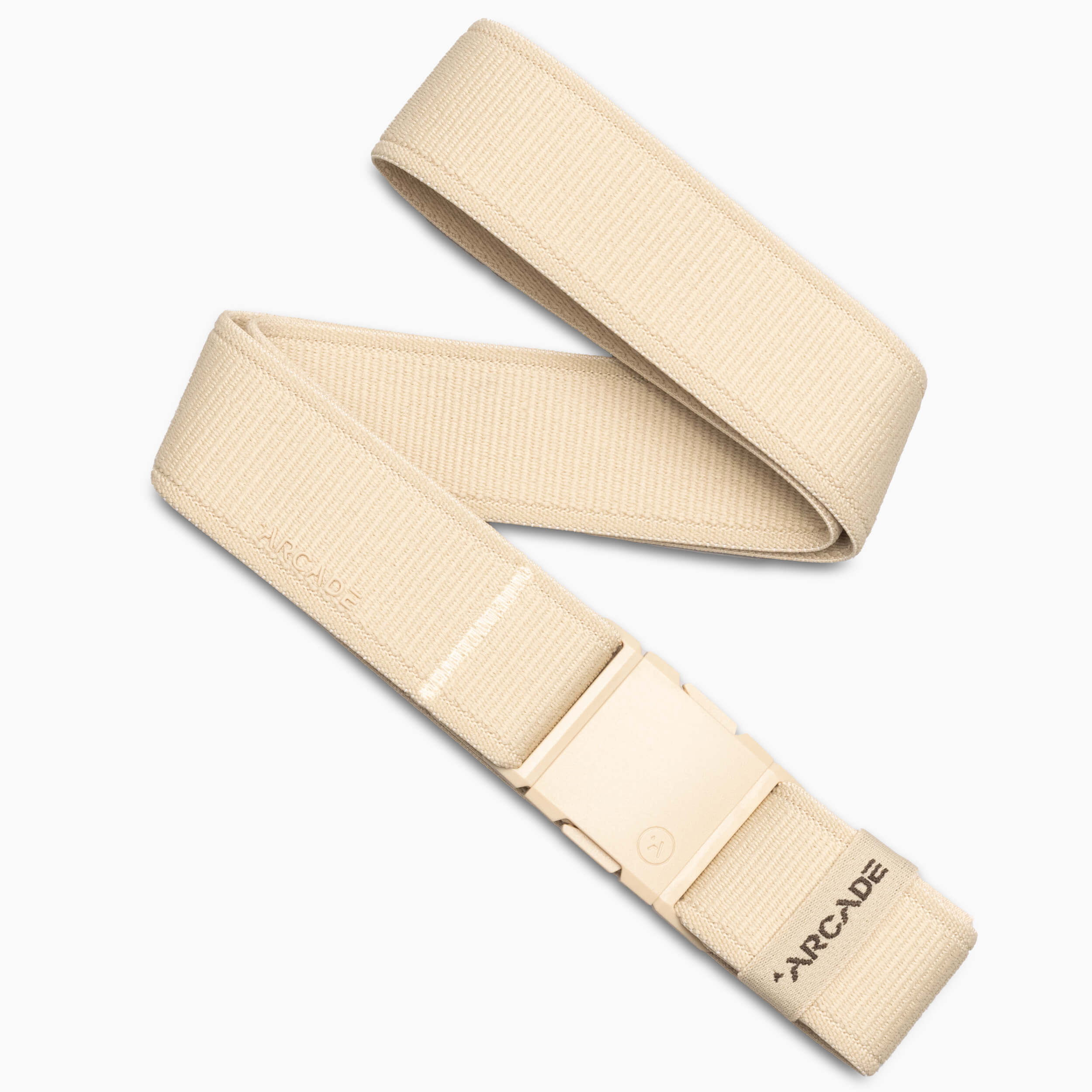 An Atlas belt by Arcade Belts in beige, featuring an adjustable elastic stretch design and a plastic buckle, with Arcade branded near the end. The belt is laid out in a loose zigzag on a white background.