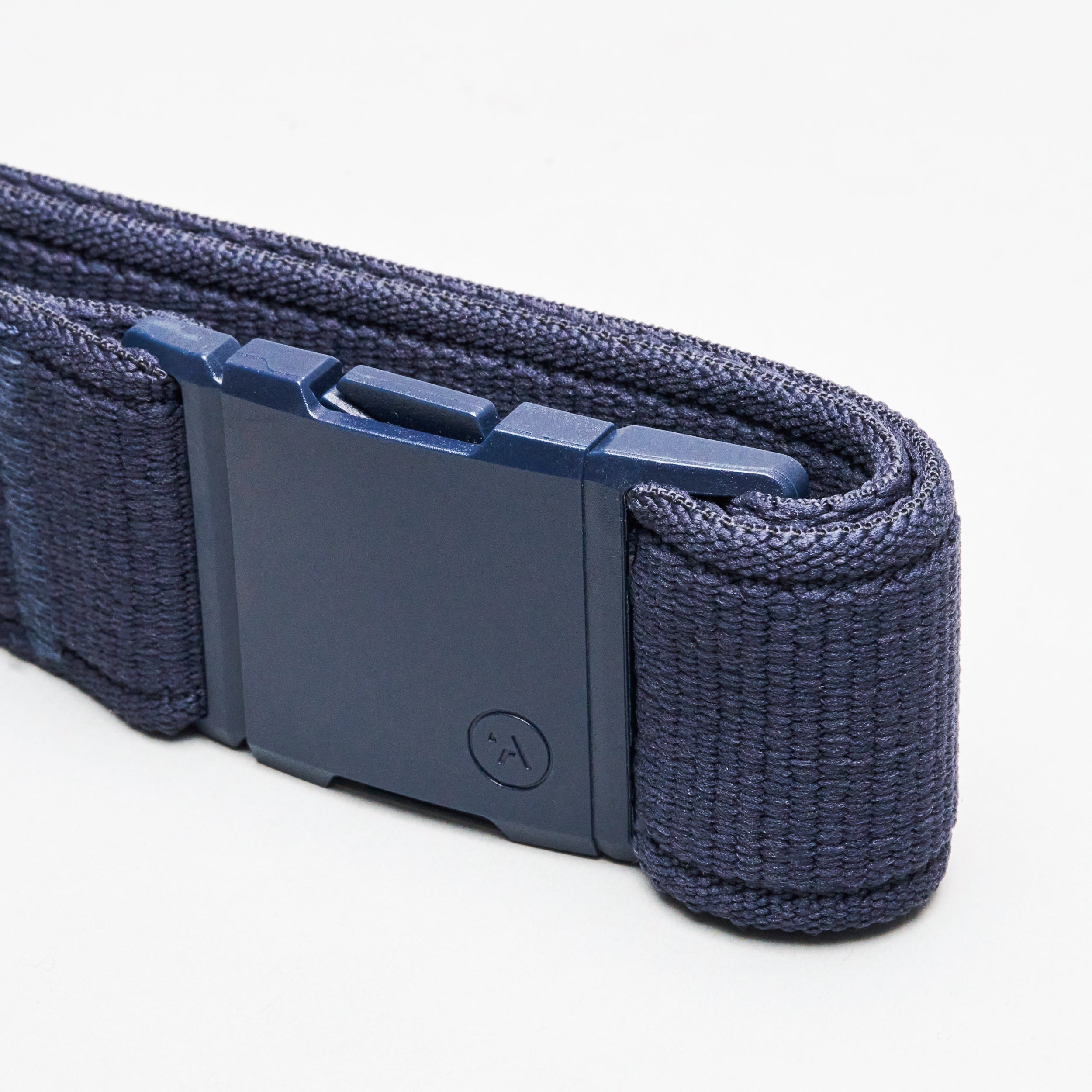 Close-up of the Atlas elastic stretch belt by Arcade Belts, in dark blue, featuring a rectangular plastic buckle, set against a plain white background.