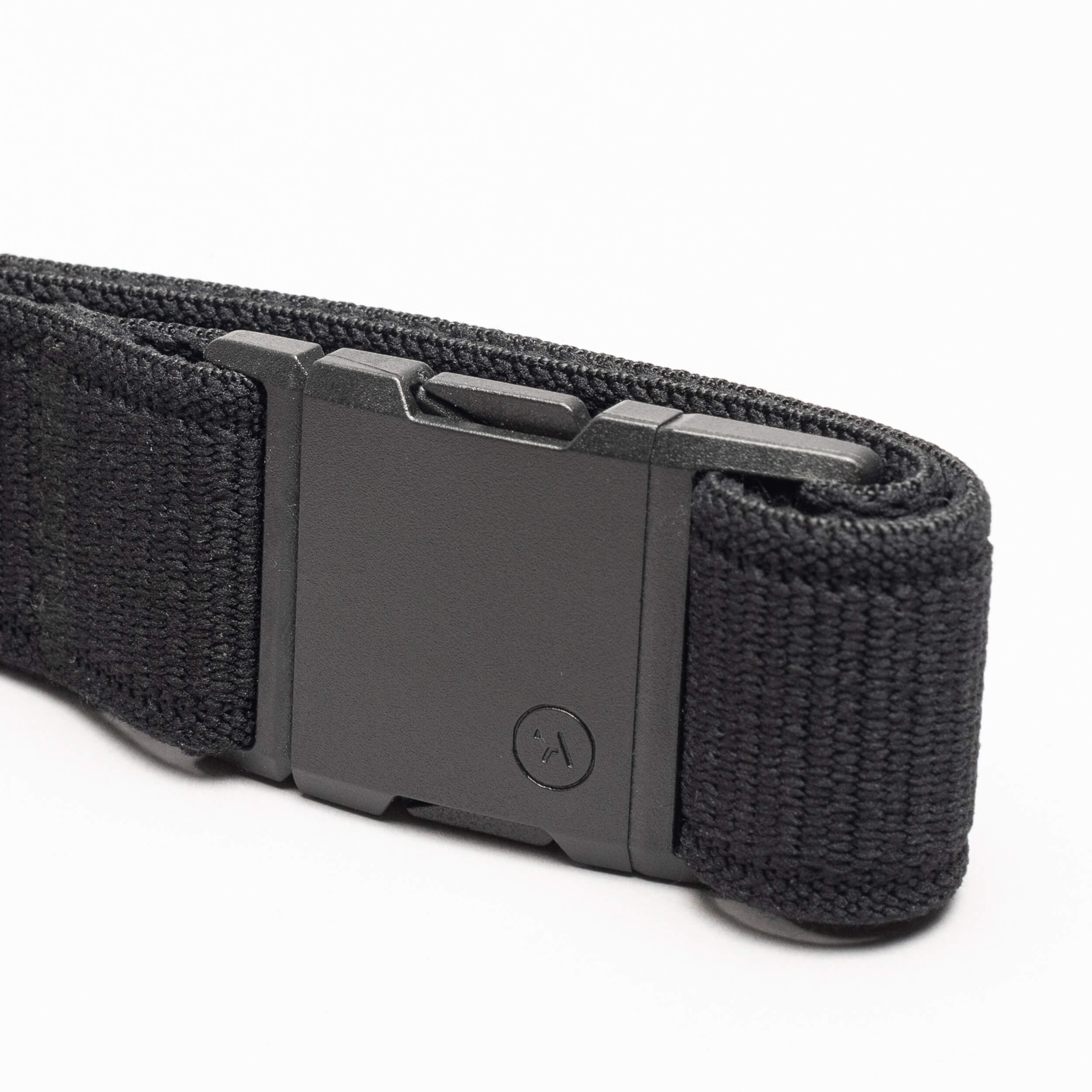 The Atlas by Arcade Belts is a black woven low-profile belt with a matte black rectangular buckle, neatly coiled on a white background—ideal for travel and daily wear.