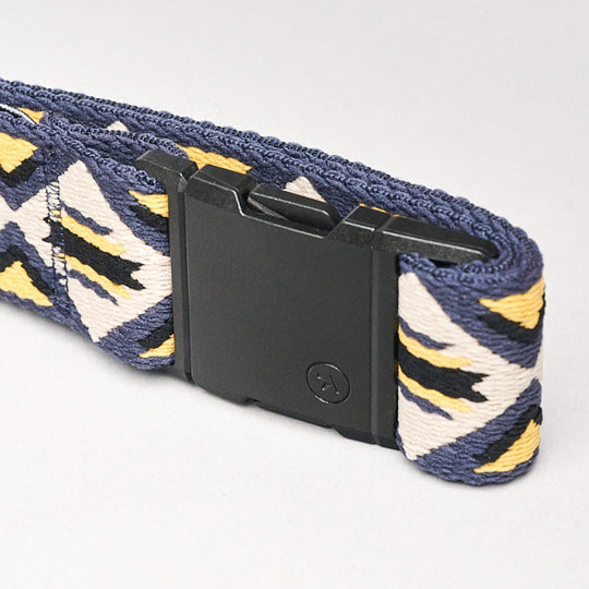 A close-up of the Vernan Kee belt by Arcade Belts, showcasing Navajo rug-inspired geometric patterns in blue, yellow, and white, finished with a black rectangular plastic buckle.