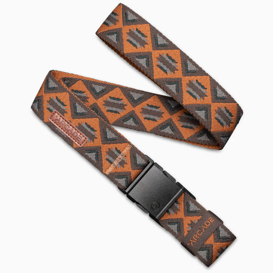 The Arcade Belts Vernan Kee is a brown and gray stretch webbing belt with a black plastic buckle, featuring a geometric triangles-and-diamonds design and a small leather patch—ideal for travel belt enthusiasts.