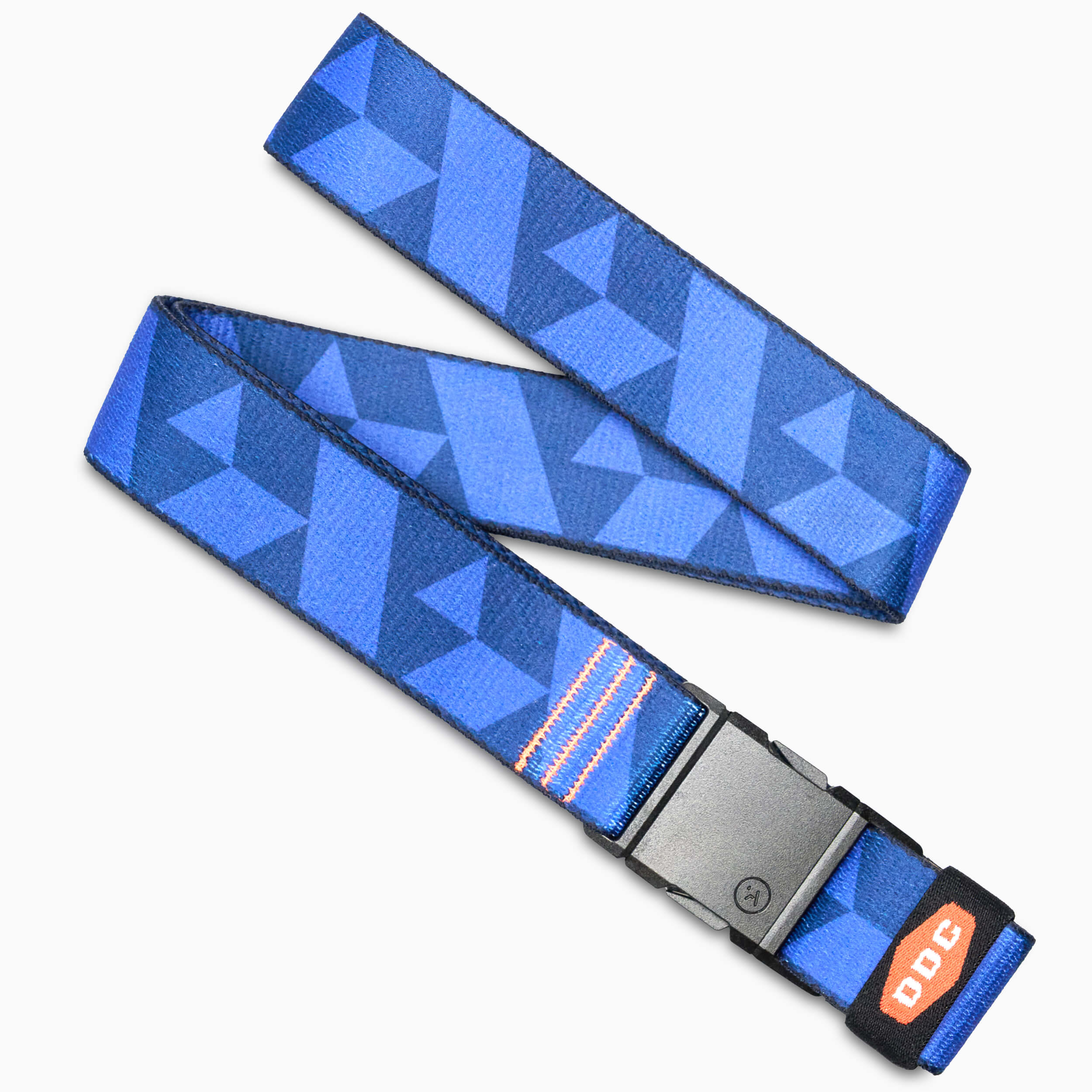 The Arcade Belts DDC is a blue-patterned belt with geometric shapes, a black plastic buckle, and an orange DDC tag. It features a low profile design and is shown laid flat on a white surface.