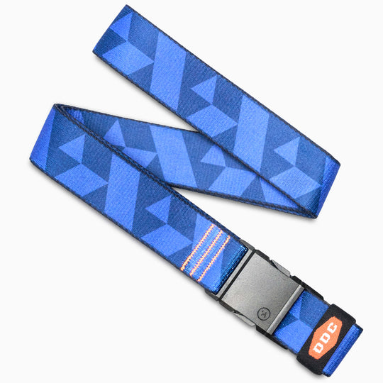 The Arcade Belts DDC is a blue-patterned belt with geometric shapes, a black plastic buckle, and an orange DDC tag. It features a low profile design and is shown laid flat on a white surface.