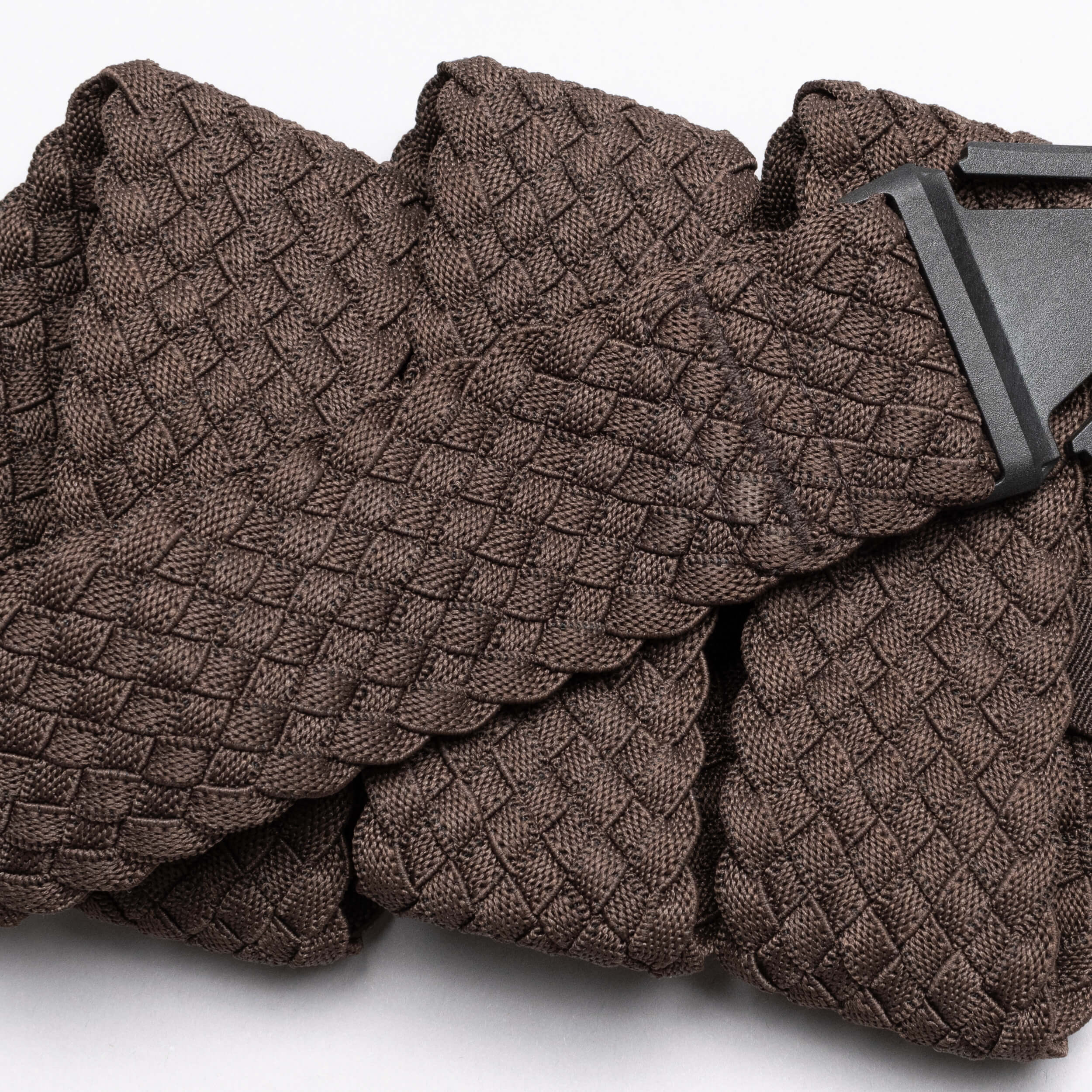 A close-up of the Arcade Belts Futureweave, a brown woven fabric belt with a textured basket-weave pattern and black buckle, shown on a white background.