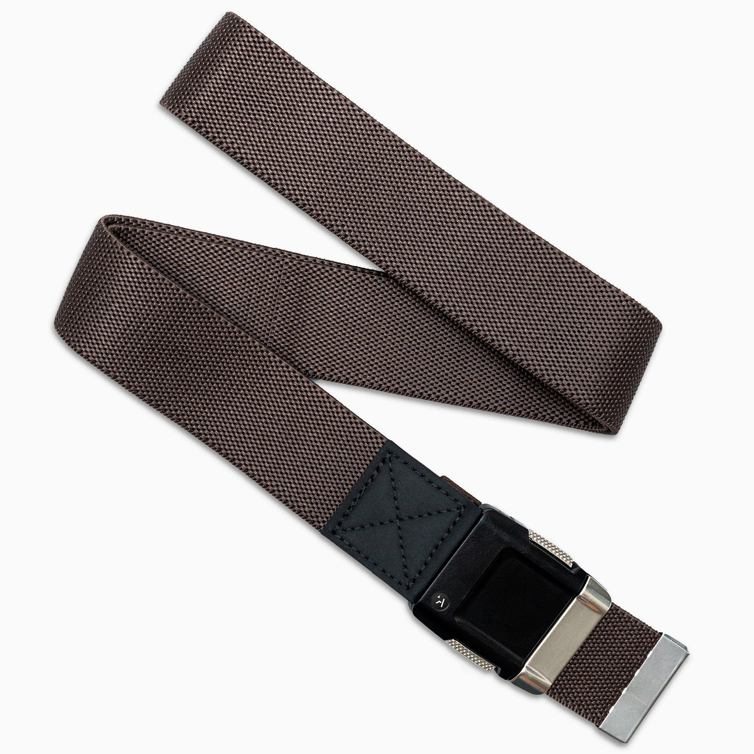 The Arcade Belts Motion is a brown stretch webbing belt with a textured pattern, black leather accent, and silver buckle. Shown loosely overlapped on a white background, this low-profile belt blends style and comfort.