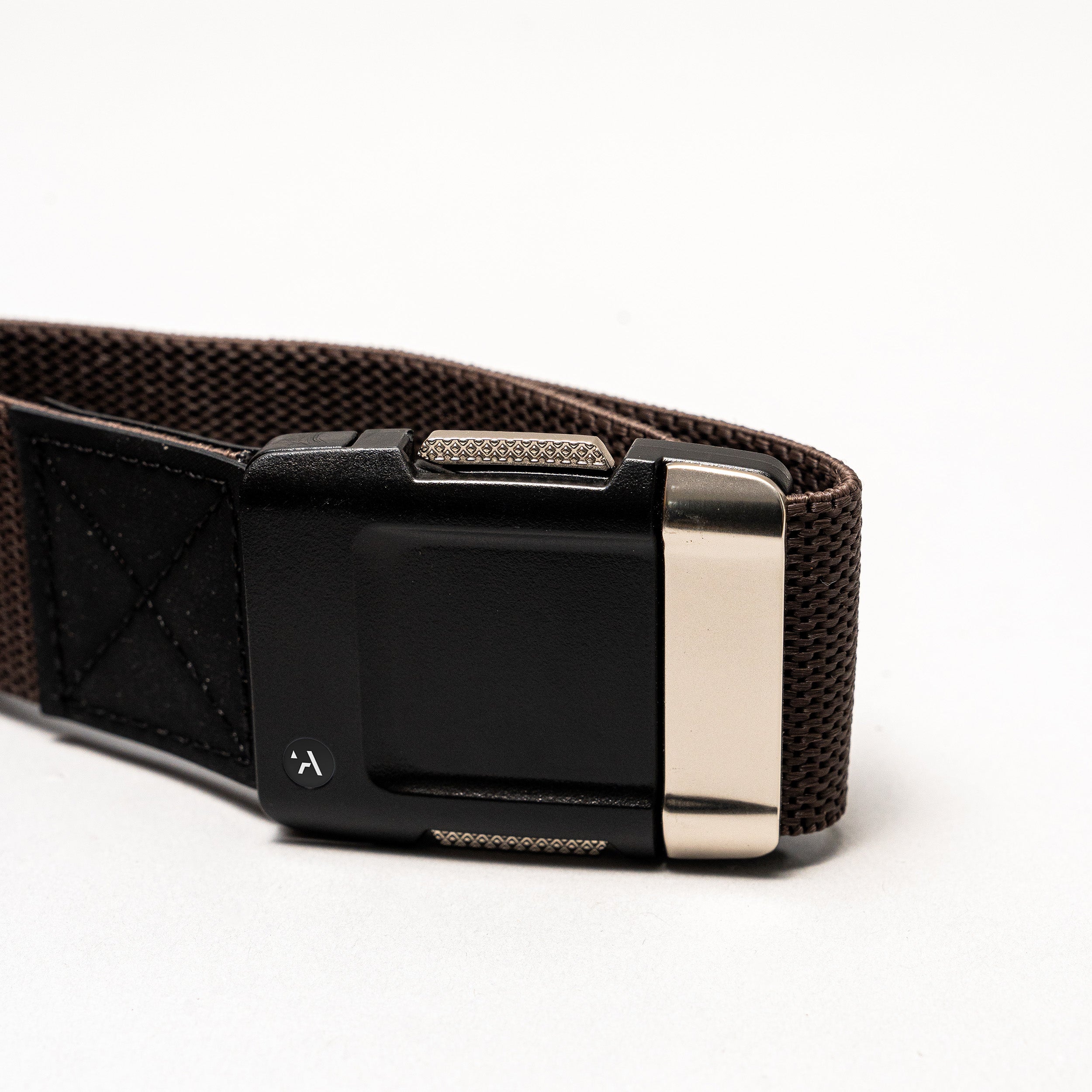 A close-up of the Arcade Belts Motion: a brown fabric belt with a black rectangular plastic buckle and metallic silver clasp, set against a plain white background—perfect as a low-profile, everyday accessory.