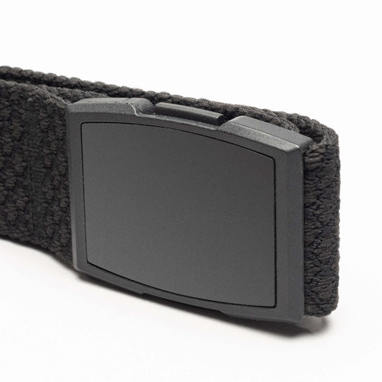 A close-up of the Arcade Belts Salient, a black elastic stretch belt with a rectangular matte black plastic buckle, shown against a white background.