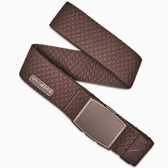 The Salient by Arcade Belts is a brown stretch webbing belt with a textured pattern and rectangular metal buckle, shown coiled in an S-shape on a white background.