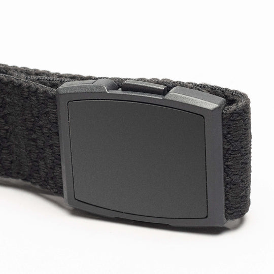 A close-up of the Salient by Arcade Belts—a black fabric belt with a matte black rectangular buckle. Its sturdy, textured stretch webbing offers comfort and durability, making it an ideal travel belt.