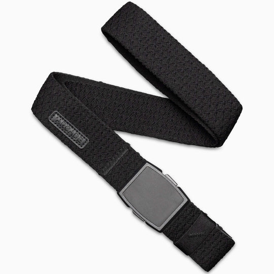 The Salient by Arcade Belts is a black woven belt with a flat, rectangular matte black plastic buckle, coiled on a white background. A small brand logo tag appears near the buckle.