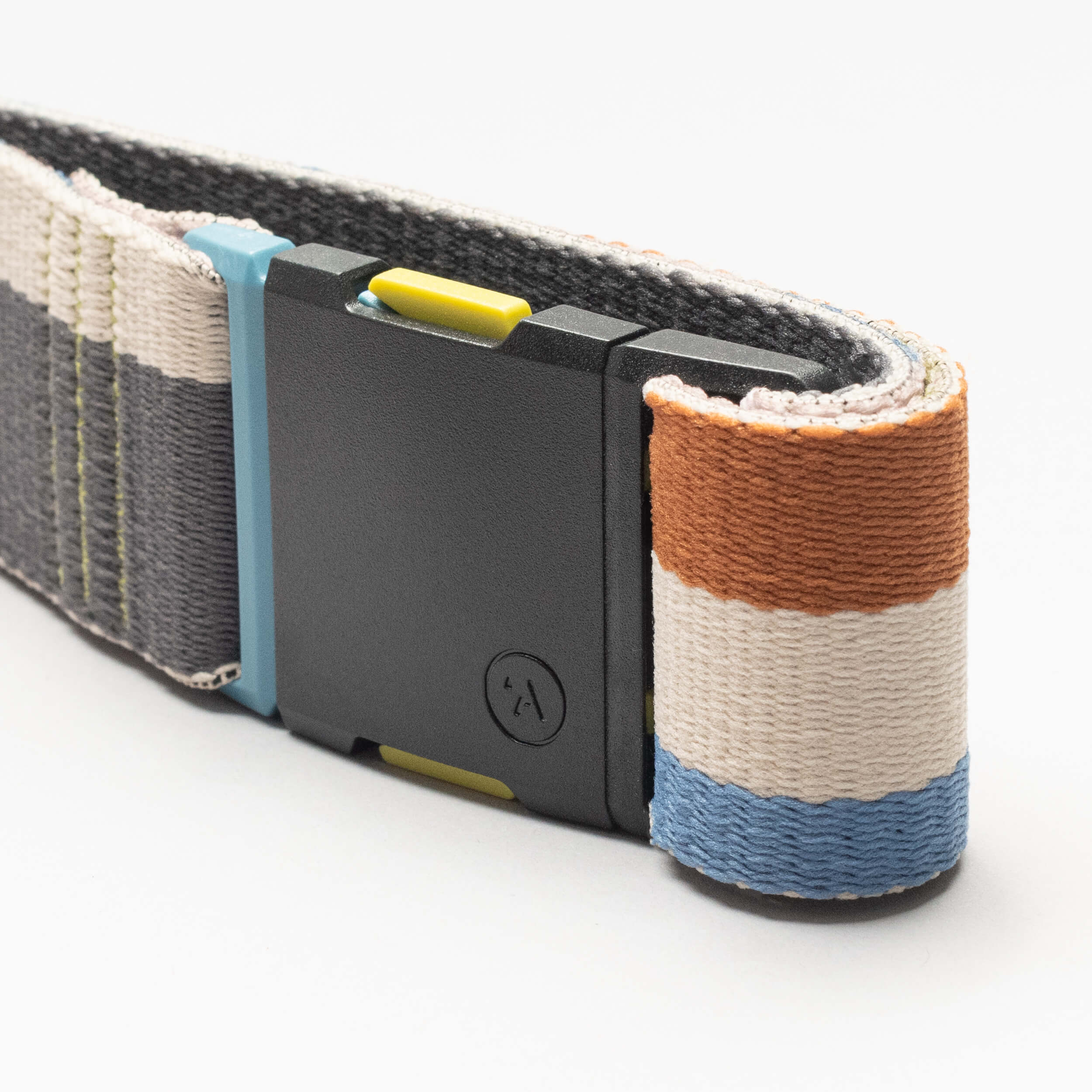 A close-up of the Arcade Belts Sierra Elastic Stretch Belt with a black plastic buckle. It has orange, white, and blue stripes at one end, gray with yellow stitching on the other, a low profile design, and a plain white background.