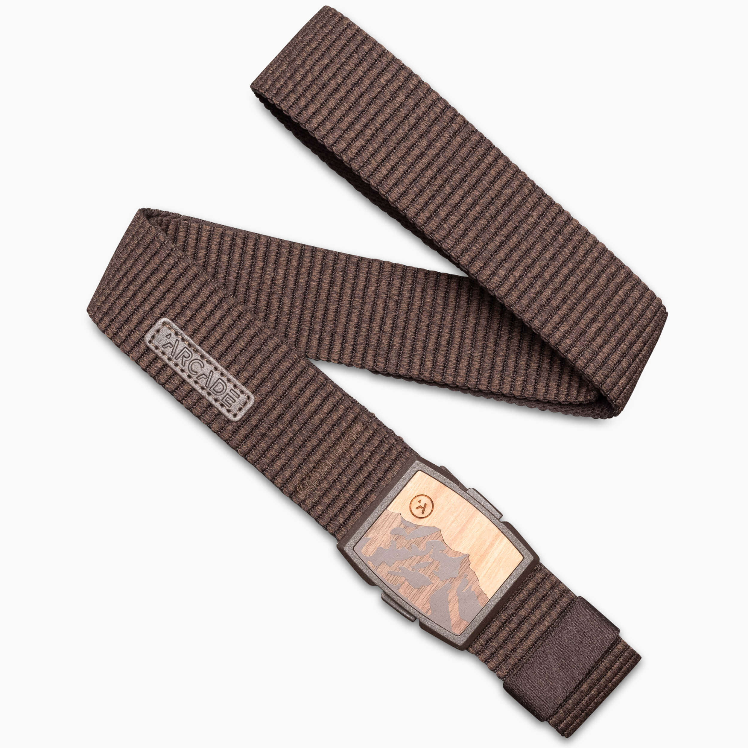 The Woody belt by Arcade Belts is a brown striped stretch belt with a rectangular metal buckle featuring a mountain design and an engraved logo tag near the buckle, shown laid out in a zigzag pattern on a white background.