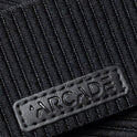 Close-up of black ribbed fabric with a rectangular stitched patch embossed with WOODY, inspired by Arcade Belts’ modern stretch webbing design.